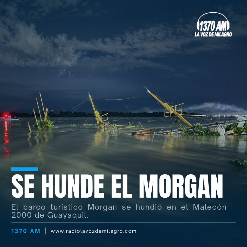 Mástiles y estructura del buque Morgan sobresaliendo del agua de noche, semihundido junto al río en Guayaquil.