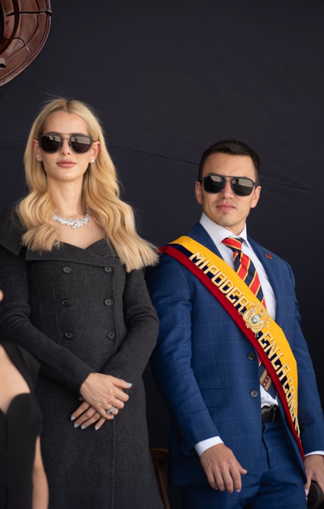 Pareja con gafas de sol, él con traje azul y banda presidencial tricolor que dice MI PODER EN LA LEY, ambos serios en acto oficial.